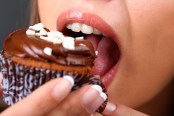 Closeup of woman eating chocolate cupcake