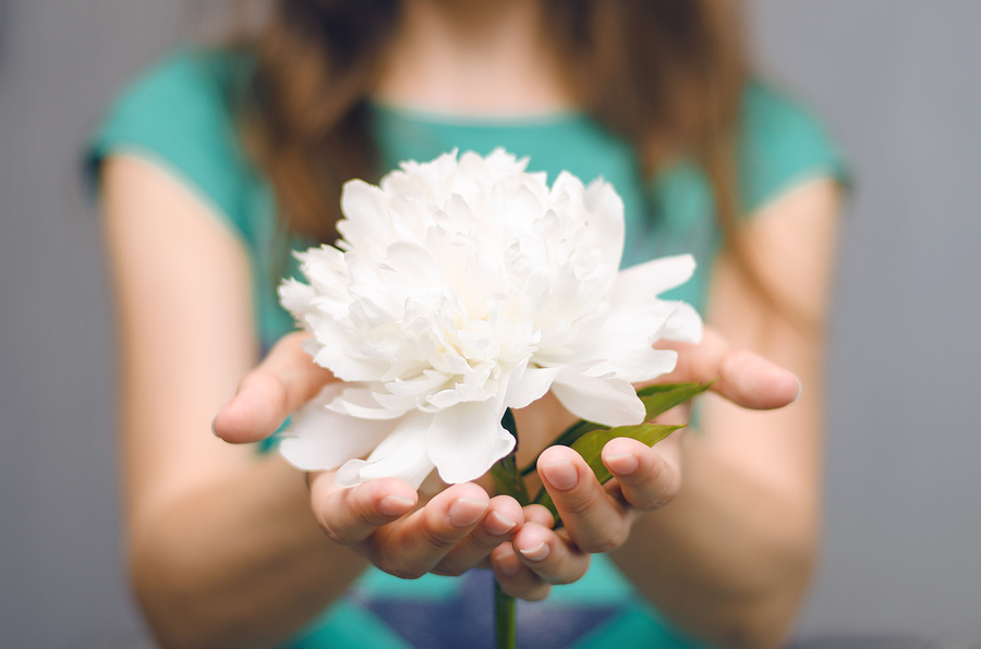 Girl holding out a flower
